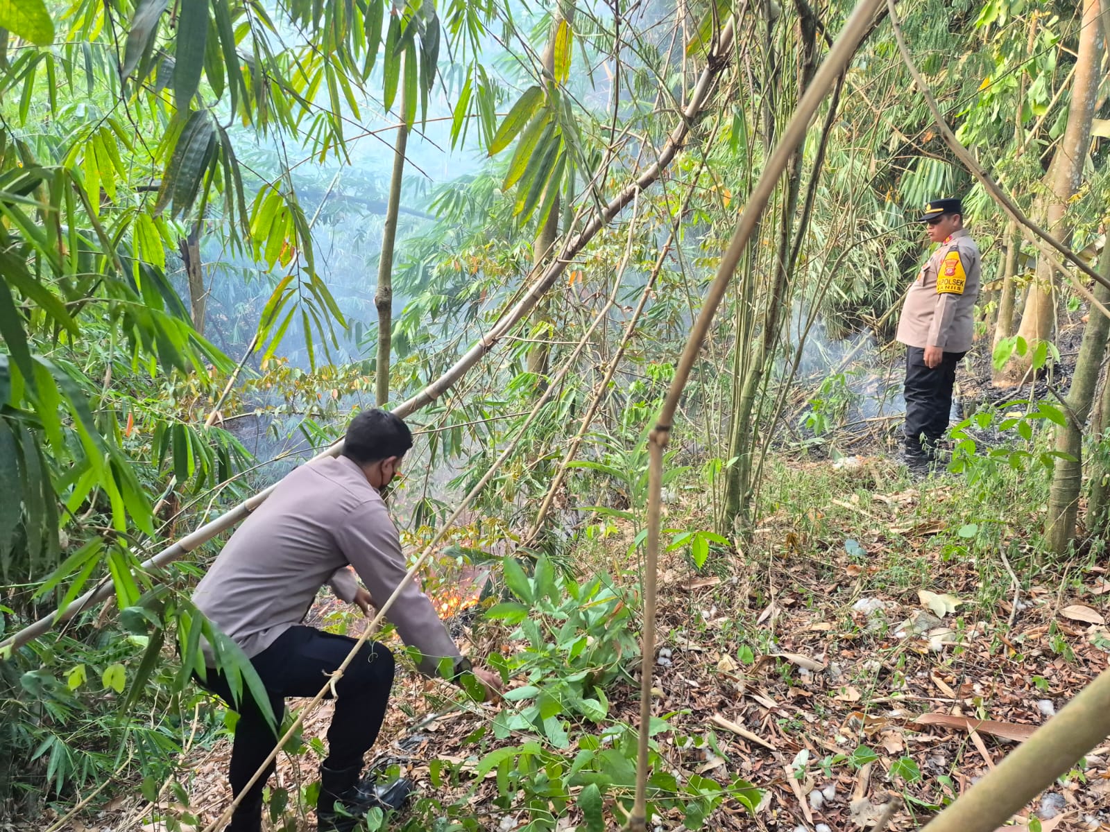 Cegah Api Meluas, Kapolsek Maniis Bersama Anggota Tangani Kebakaran Kebun Bambu