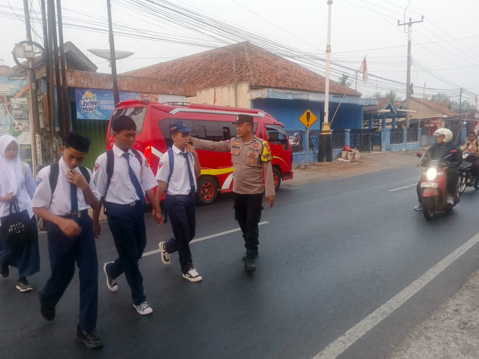 Pelayanan Sederhana yang Berarti, Bhabinkamtibmas Polsek Cibatu Bantu Pelajar Menyeberang Jalan